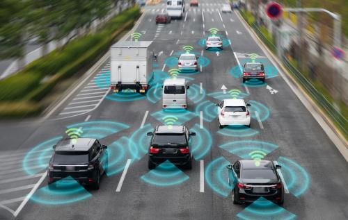 Cars travelling down a four lane road. An overlay shows radiating lines in four directions from each vehicle, and an indication of a wi-fi signal on top.